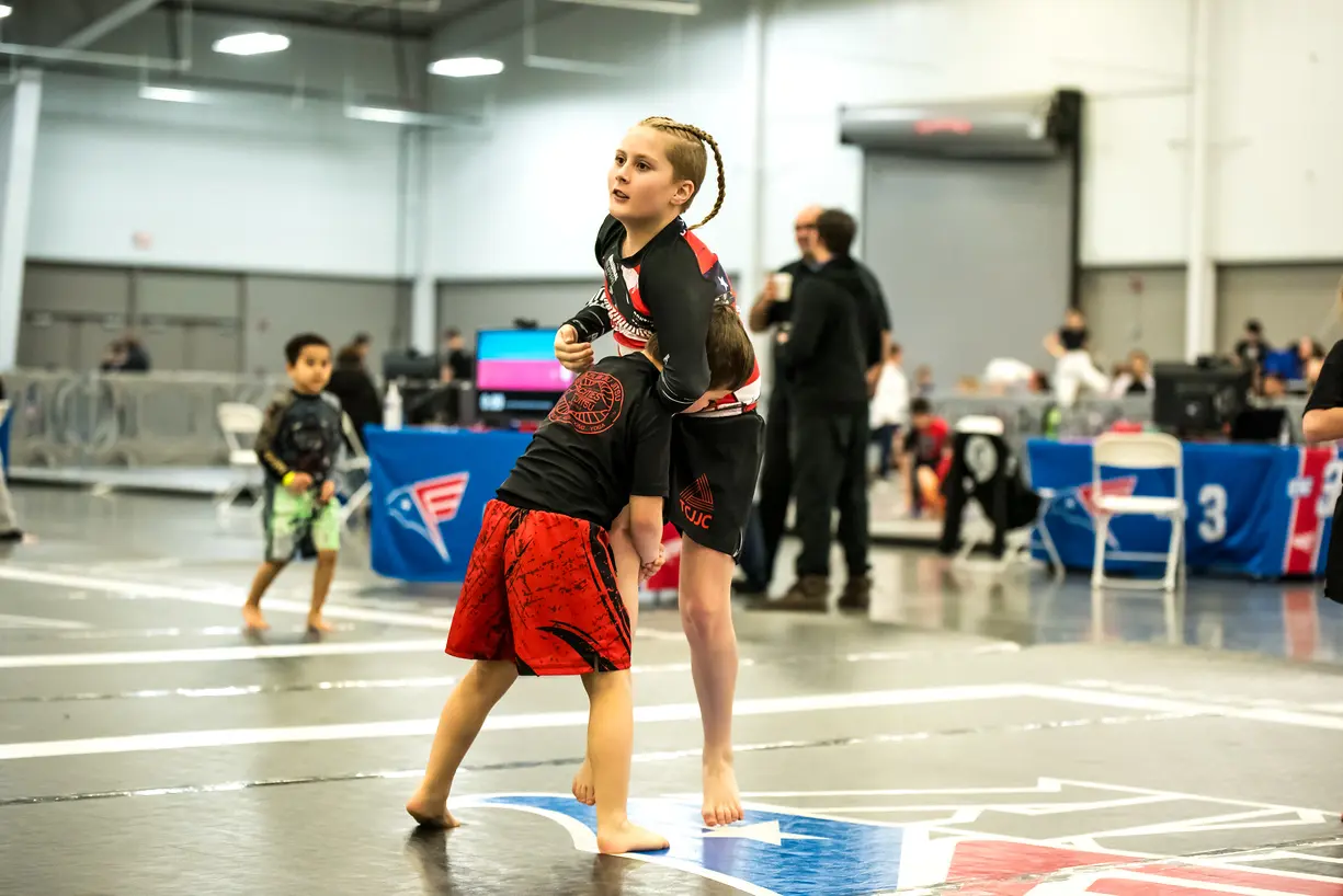 Younger kids can train in Royce Gracie family Jiu-Jitsu, starting with self-defense training and progressing through belts like white belt, purple belt, and black belt, while enjoying physical and mental benefits.